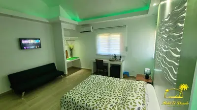 a bedroom with a bed and a couch and a desk at Hotel El Dorado in La Romana