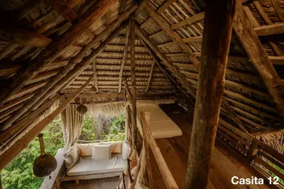 an attic room with a bed and a window at Ecolodge Tubagua Puerto Plata in Tubagua