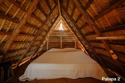 a bed in a wooden room in a attic at Ecolodge Tubagua Puerto Plata in Tubagua