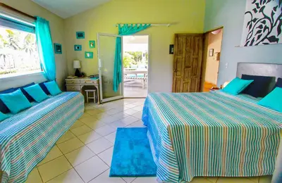a bedroom with two beds and a door to a patio at Villa Talanquera in Las Galeras