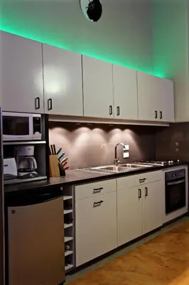 a kitchen with white cabinets and a sink and a microwave at Villa Talanquera in Las Galeras