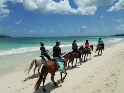 a group of people riding horses on the beach at Villa Talanquera in Las Galeras