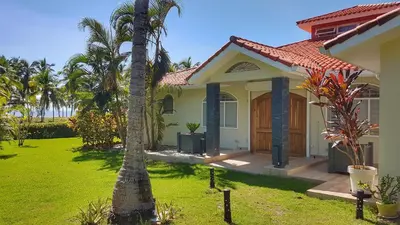 a house with a palm tree in the yard at Villa Talanquera in Las Galeras