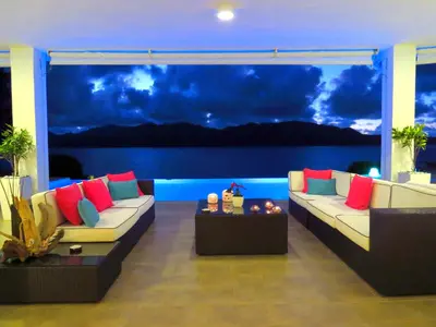 a living room with couches and a view of the water at Villa Salamandra in Las Galeras
