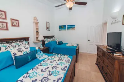a bedroom with two beds and a flat screen tv at Villa Maud in La Romana