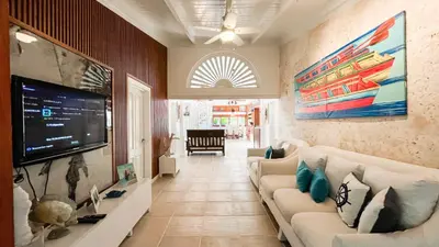 a living room with a couch and a flat screen tv at Villa Maud in La Romana