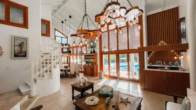 a living room with a chandelier and a table at Villa Maud in La Romana