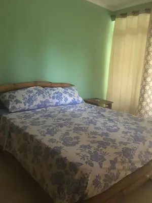 a bedroom with a bed with a blue and white comforter at Casa Altea in Santa Bárbara de Samaná