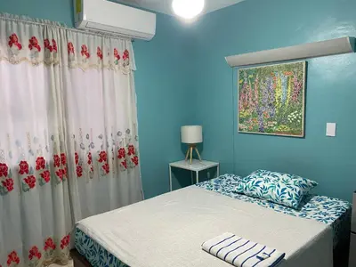 a bedroom with a bed and a blue wall at Casa Azul - Apartment in San Felipe de Puerto Plata