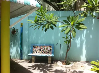 a bench in front of a blue wall with plants at Casa Azul - Apartment in San Felipe de Puerto Plata