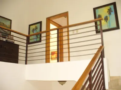 a staircase in a house with a wooden railing at Villas Del Jardin 7 in Juan Dolio