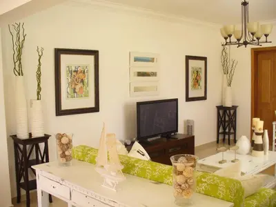 a living room with a couch and a tv at Villas Del Jardin 7 in Juan Dolio