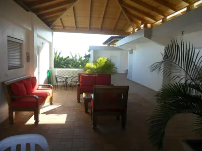 a patio with red chairs and a table and plants at Centro de Santiago in Santiago de los Caballeros