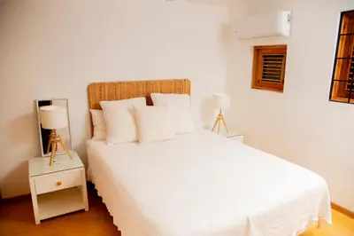 a bedroom with a white bed with two lamps at Jasmine La Playita - Ocean Front in Las Galeras