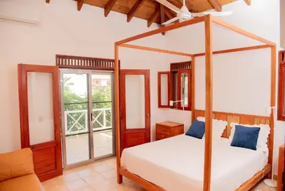 a bedroom with a four poster bed and a window at Villa Diana in Las Galeras