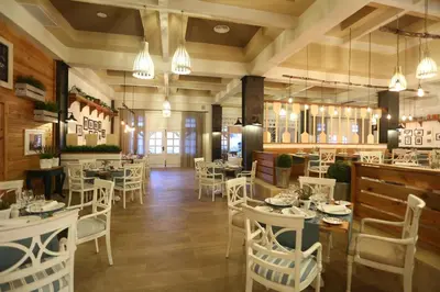 a restaurant with white chairs and tables and a bar at Bahia Principe Fantasia Punta Cana - All Inclusive in Punta Cana