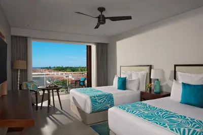 a hotel room with two beds and a balcony at Dreams Dominicus La Romana Resort & Spa in Bayahibe