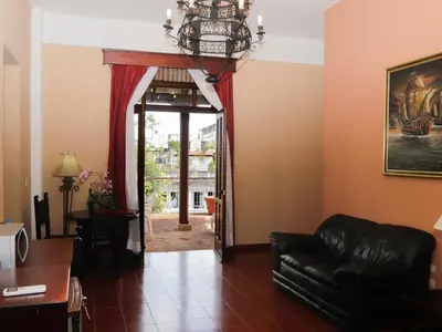 a living room with a couch and a chandelier at Boutique Hotel Palacio in Santo Domingo