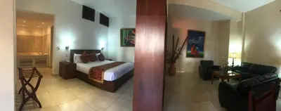 a bedroom with a bed and a living room at Boutique Hotel Palacio in Santo Domingo