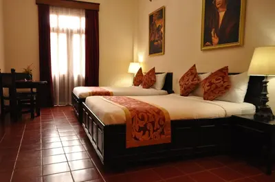 a hotel room with two beds and a window at Boutique Hotel Palacio in Santo Domingo