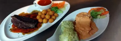 a plate of food with meat and vegetables on a table at Hotel Don Andres in Sosúa