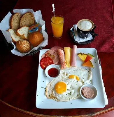 a plate of food with eggs and bread on a table at Hotel Don Andres in Sosúa