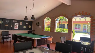a room with a pool table and some windows at Hotel Don Andres in Sosúa