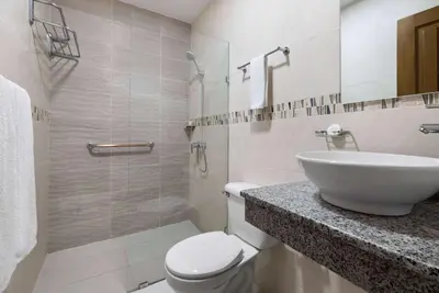 a bathroom with a toilet and a sink and a shower at Gran Hotel Europa Santo Domingo Trademark Collection by Wyndham in Santo Domingo