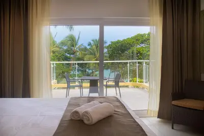a room with a bed with a view of a balcony at Hotel Villa Taina in Cabarete