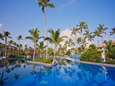 a pool at a resort with palm trees at Ocean Blue & Sand Beach Resort - All Inclusive in Punta Cana