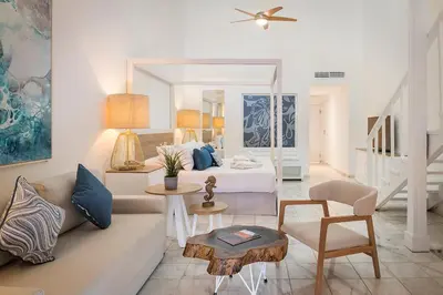 a living room with a couch and a bed and a table at Ocean Blue & Sand Beach Resort - All Inclusive in Punta Cana