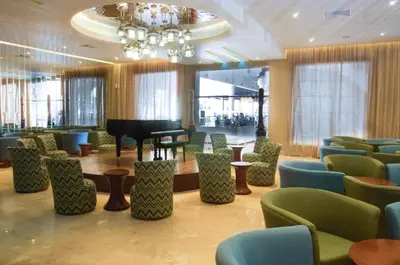 a waiting room with a grand piano and chairs at Ocean Blue & Sand Beach Resort - All Inclusive in Punta Cana