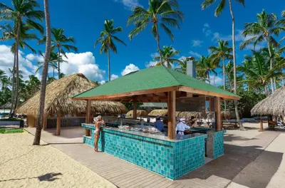 a bar on the beach with palm trees at Grand Sirenis Punta Cana Resort & Aquagames - All Inclusive in Punta Cana