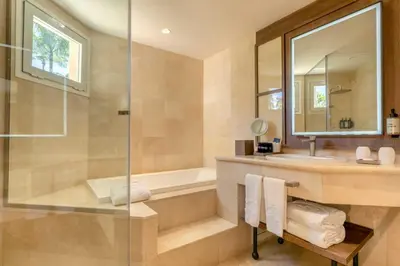 a bathroom with a shower and a tub and a sink at Grand Palladium Select Bávaro - All Inclusive in Punta Cana