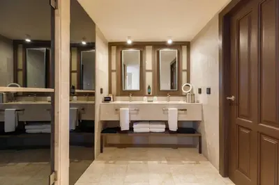 a bathroom with two sinks and two mirrors at Grand Palladium Select Bávaro - All Inclusive in Punta Cana
