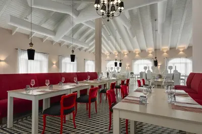 a dining room with tables and red chairs at Grand Palladium Punta Cana Resort & Spa - All Inclusive in Punta Cana