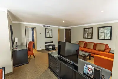 a living room with a couch and a television at Dominican Fiesta Hotel in Santo Domingo