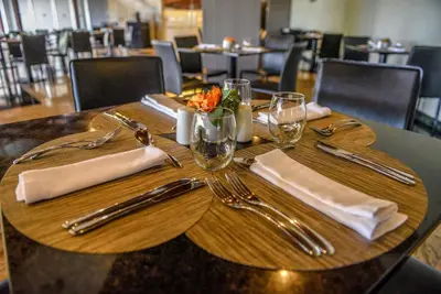 a wooden table with utensils on top of it at Dominican Fiesta Hotel in Santo Domingo