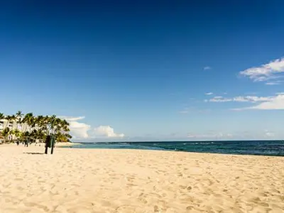 a person standing on a beach near the ocean at Plaza Real Resort in Juan Dolio