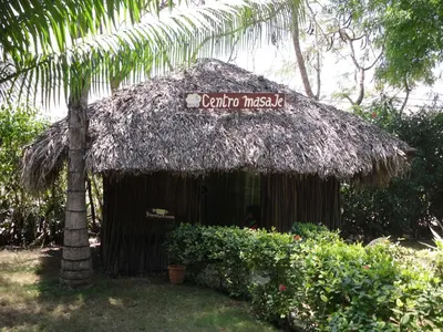 a thatch hut with a sign on top of it at Plaza Real Resort in Juan Dolio
