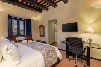 a bedroom with a bed and a desk and a television at Hodelpa Nicolás de Ovando in Santo Domingo