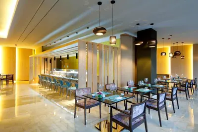 a dining room with tables and chairs and a bar at TRS Turquesa Hotel - Adults Only - All Inclusive in Punta Cana