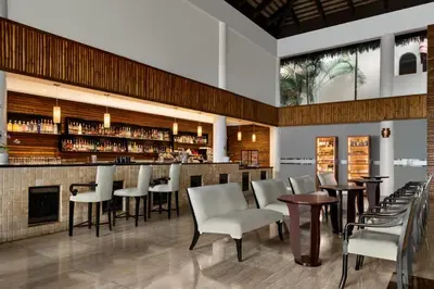 a restaurant with a bar with white chairs and tables at TRS Turquesa Hotel - Adults Only - All Inclusive in Punta Cana
