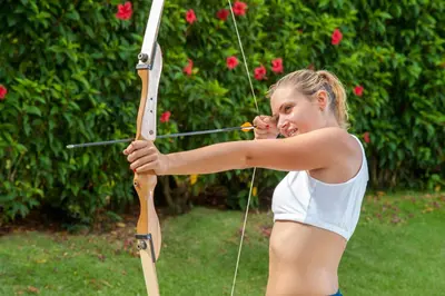a young woman holding a bow and arrow at Grand Bavaro Princess - All Inclusive in Punta Cana