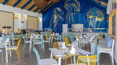 a restaurant with tables and chairs and a blue wall at Punta Cana Princess Adults Only - All Inclusive in Punta Cana