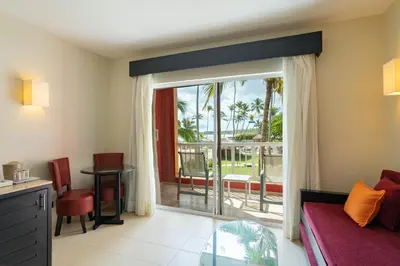 a living room with a sliding glass door to a balcony at Punta Cana Princess Adults Only - All Inclusive in Punta Cana