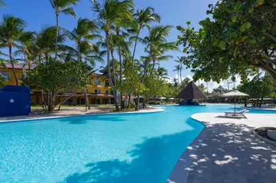 a pool at the resort with palm trees at Caribe Deluxe Princess - All Inclusive in Punta Cana