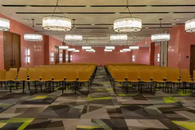 a conference room with yellow chairs and red walls at Caribe Deluxe Princess - All Inclusive in Punta Cana