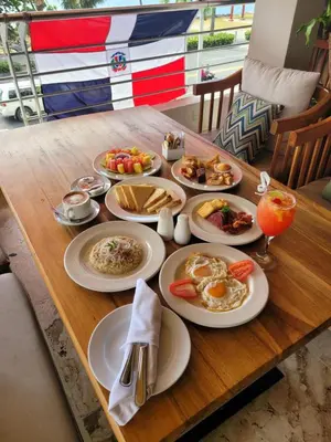 a table with plates of breakfast food on it at Napolitano Hotel in Santo Domingo
