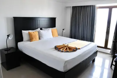 a bedroom with a large bed with a wooden headboard at Napolitano Hotel in Santo Domingo